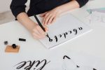 close-up-photo-of-young-woman-hands-writing-alphab-RNCVPX3.jpg